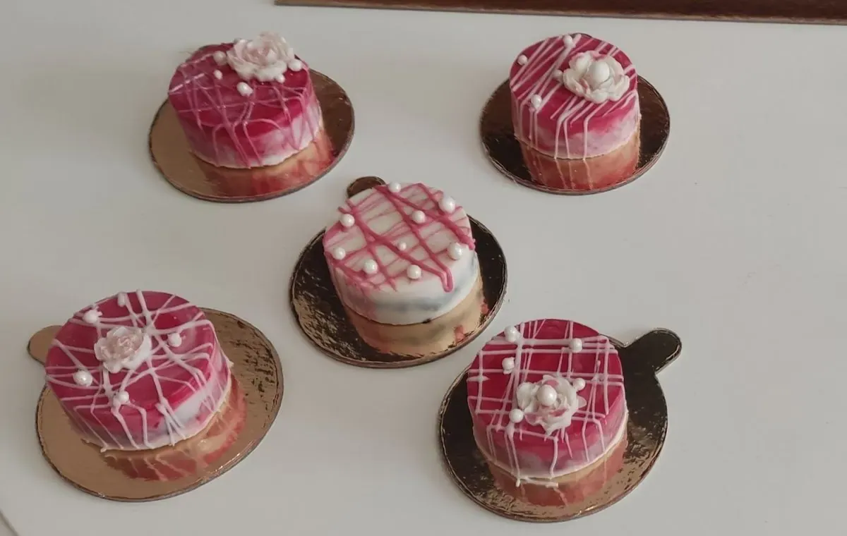 Mini torte sa roze glazurom i čokoladnim cvetom na zlatnim podlogama