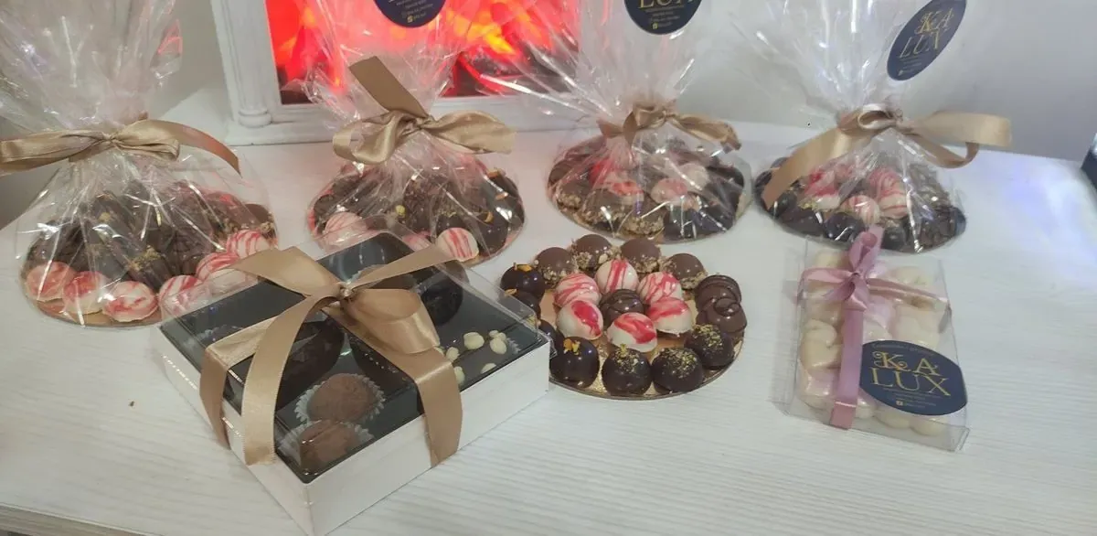 Poklon pakovanja pralina u celofanu i kutija sa zlatnom mašnom