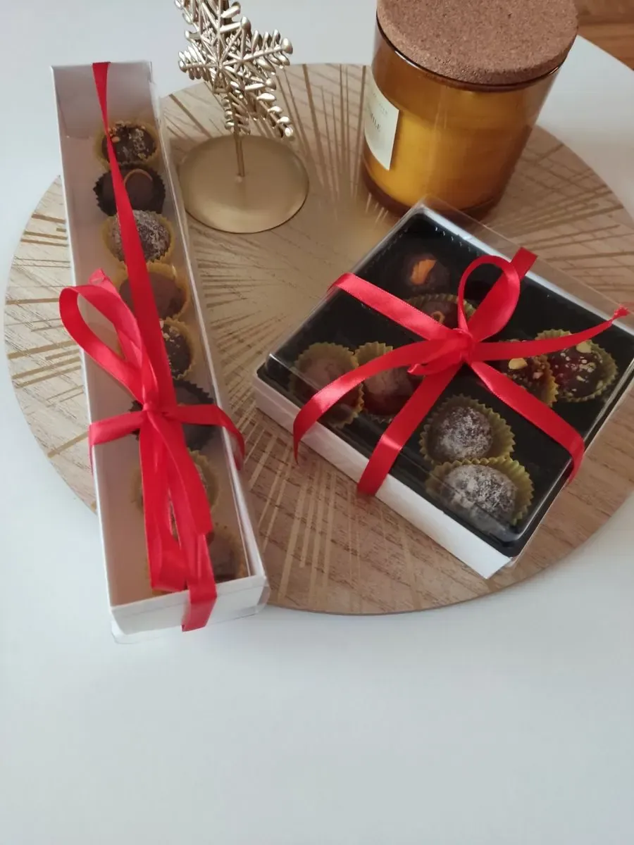 Poklon pakovanja sa trufama i pralinama vezana crvenim mašnama
