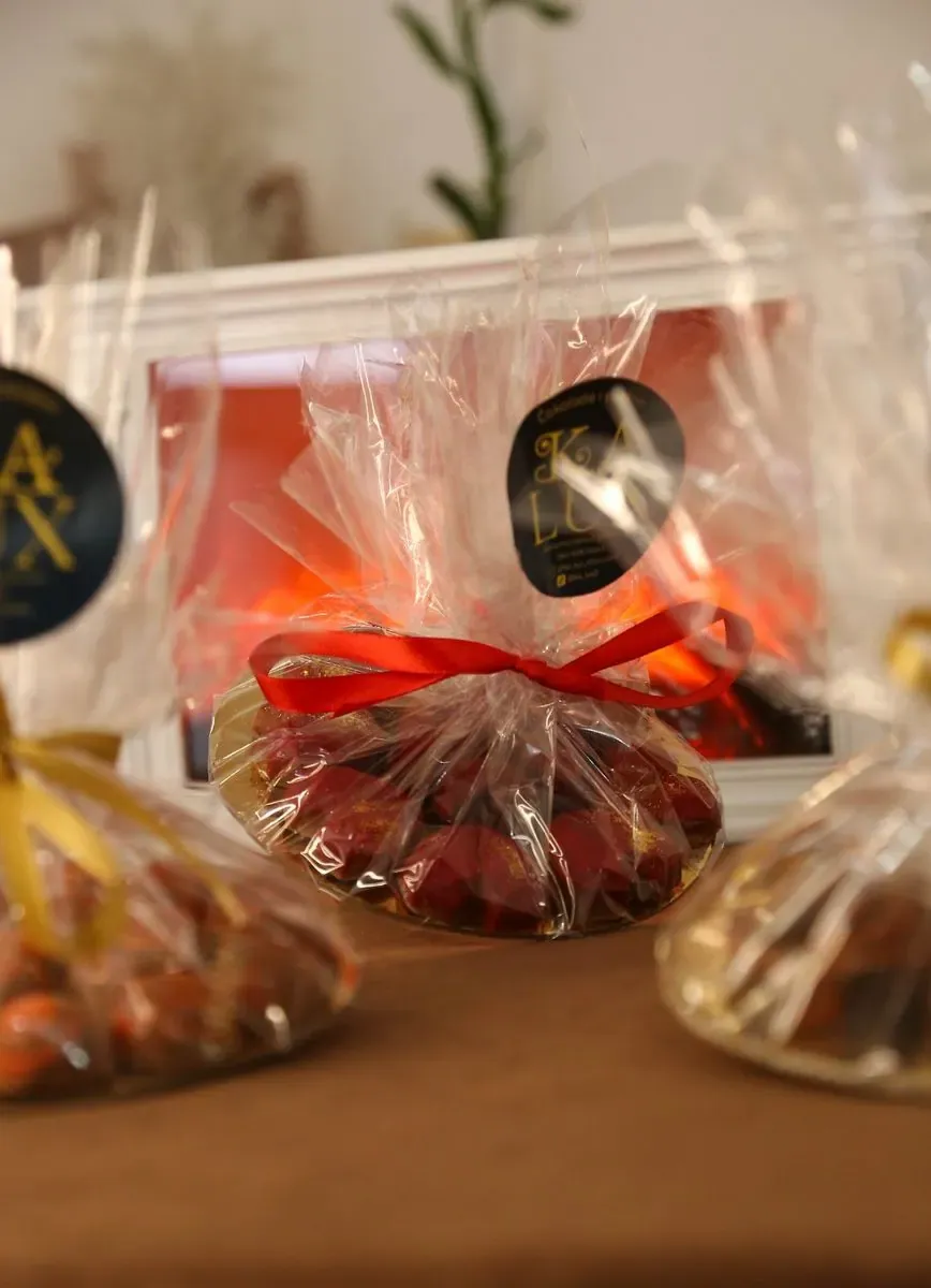 Praline upakovane u celofan sa crvenom mašnom i Ka Lux nalepnicom